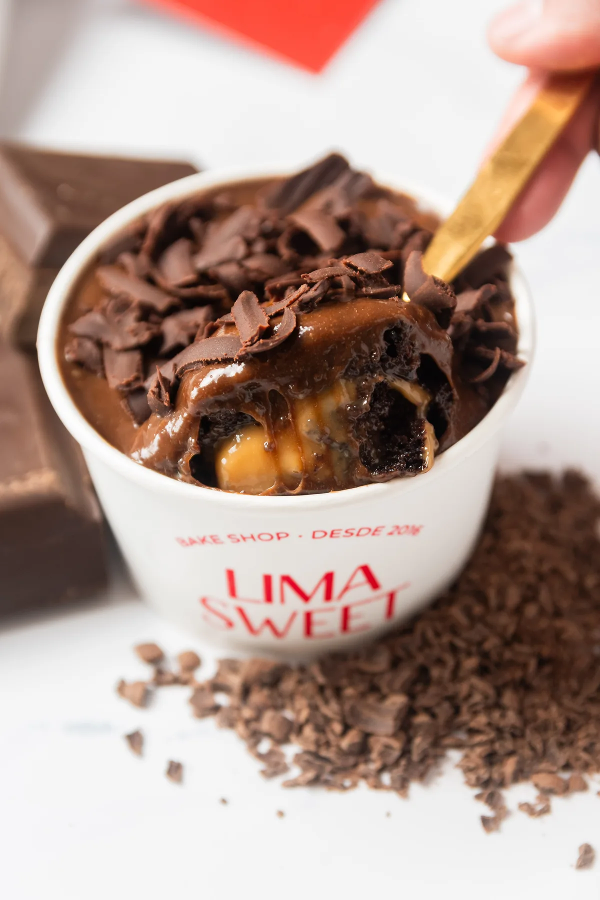 Cuchara con un bocado de bizcocho de chocolate relleno de manjar