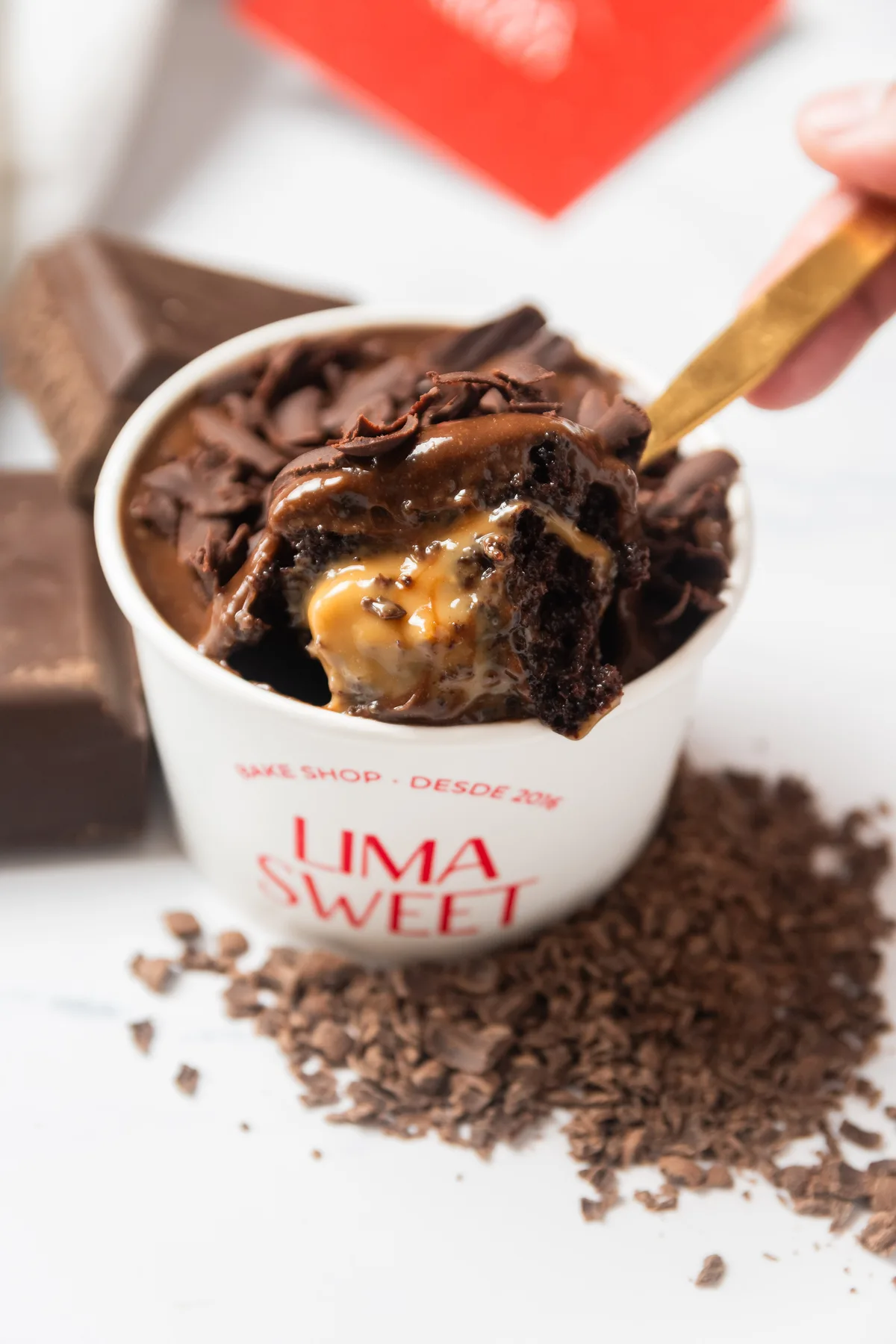 Cuchara en alto con chocolate y manjar goteando