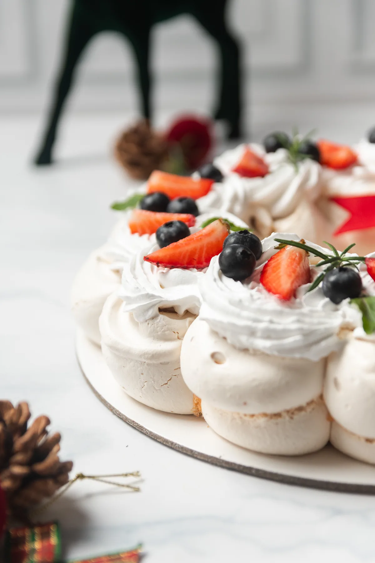 Corona de mini pavlovas con crema chantilly, fresas y arándanos, decoración navideña