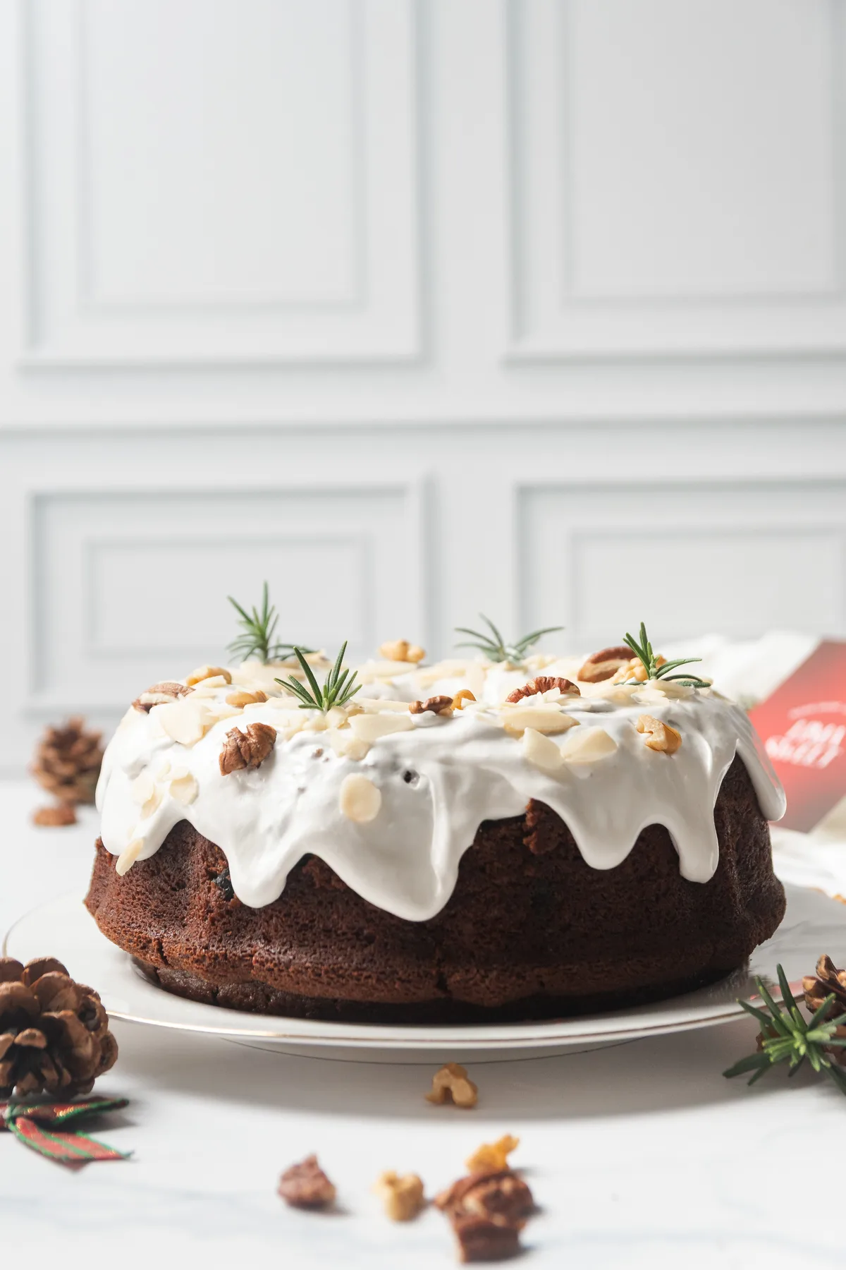Bundt cake de especias con glaseado goteando, nueces y romero, tarjeta roja de marca