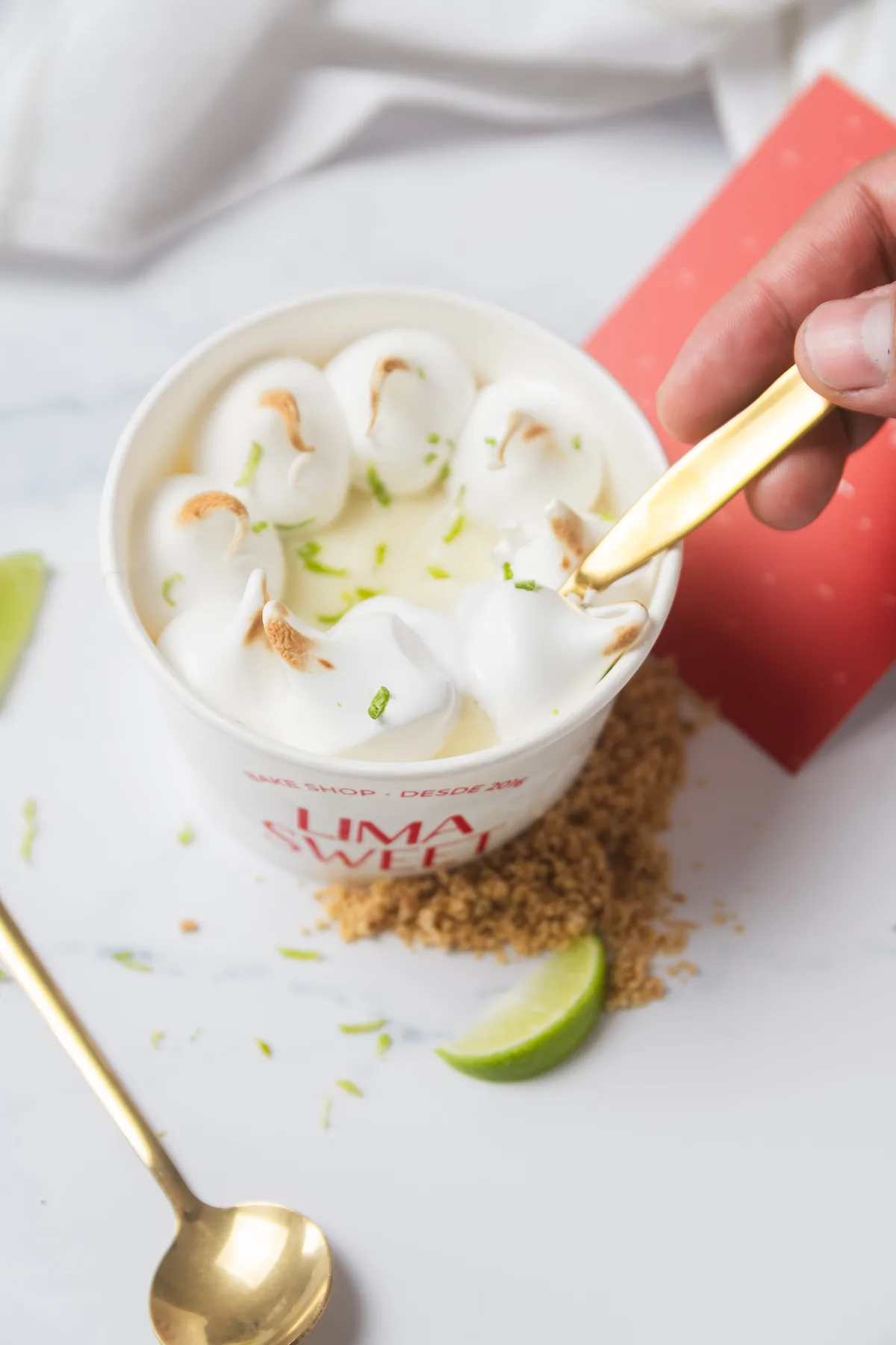 Cuchara con un bocado del vasito, con el relleno cremoso de limón a la vista