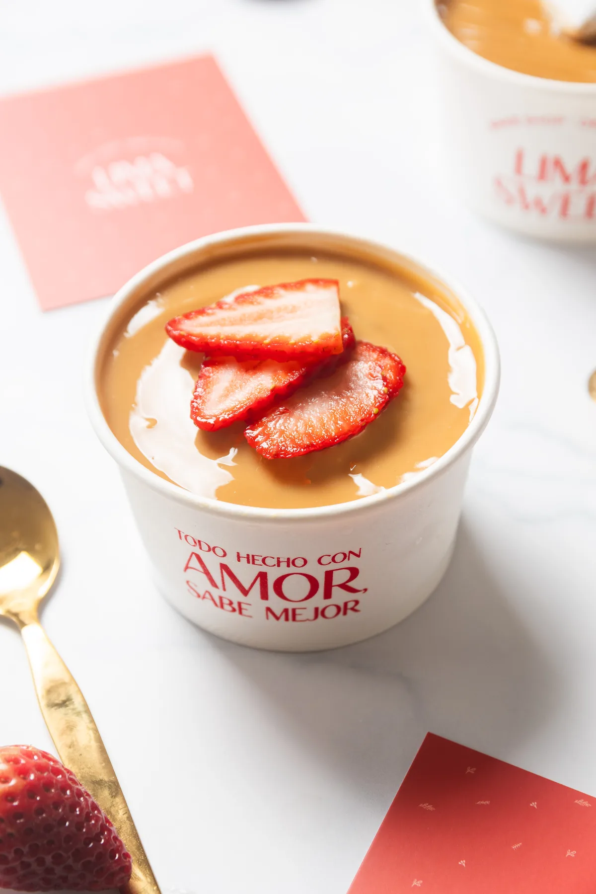 Vasito de tres leches con crema de caramelo y fresas laminadas encima