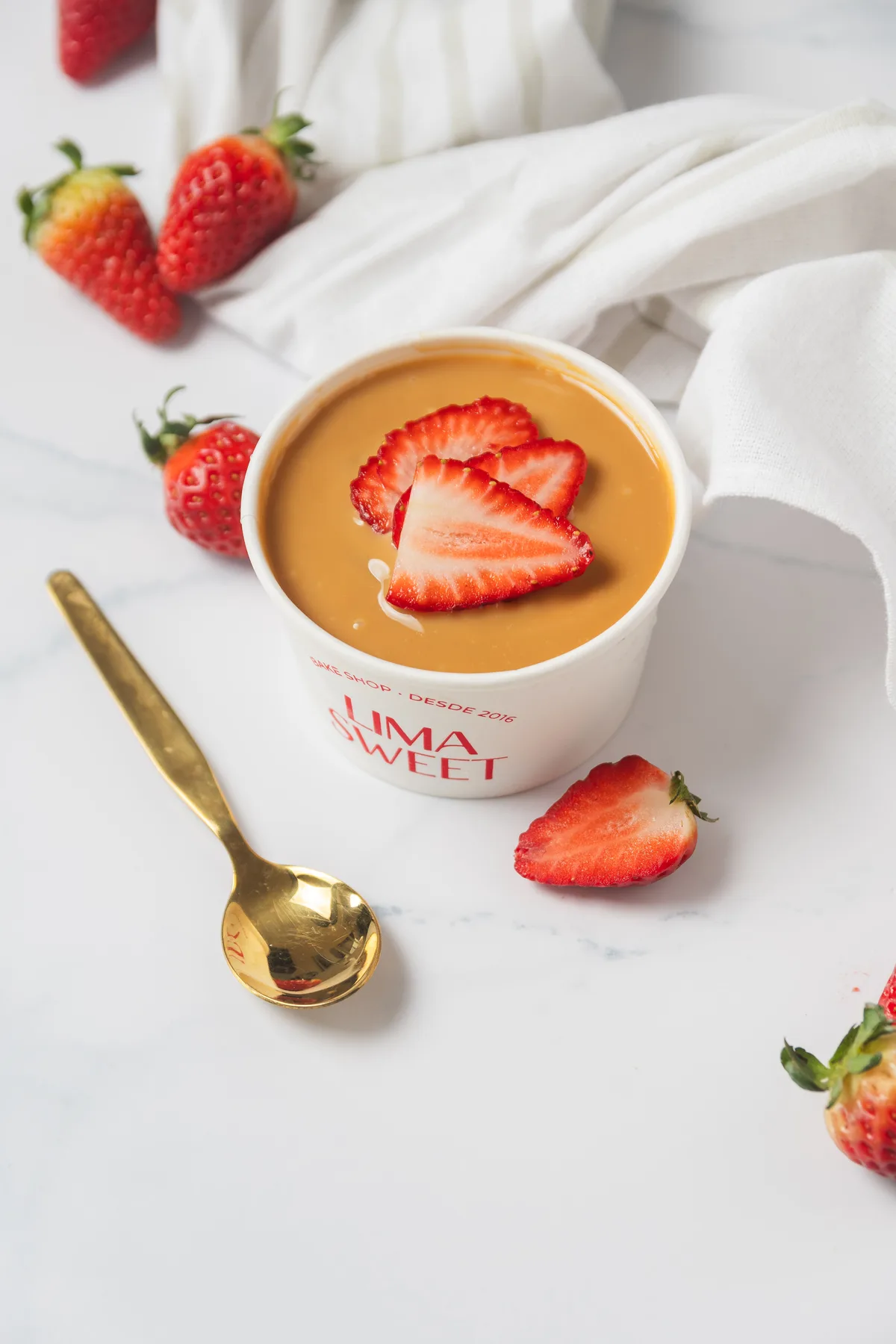 Vasito de tres leches con más fresas frescas alrededor